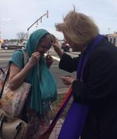 A woman is crying while another person holds her hand up to her face.