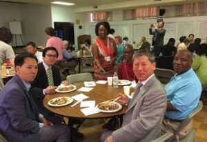 A group of people sitting around a table with plates.