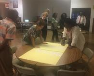 A group of people standing around a table.