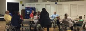 A group of people sitting around tables in a room.