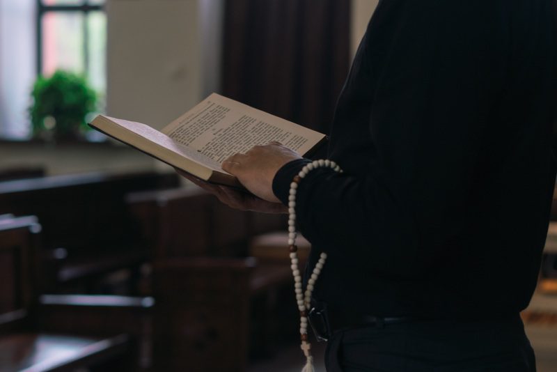 A person holding an open book in their hands.