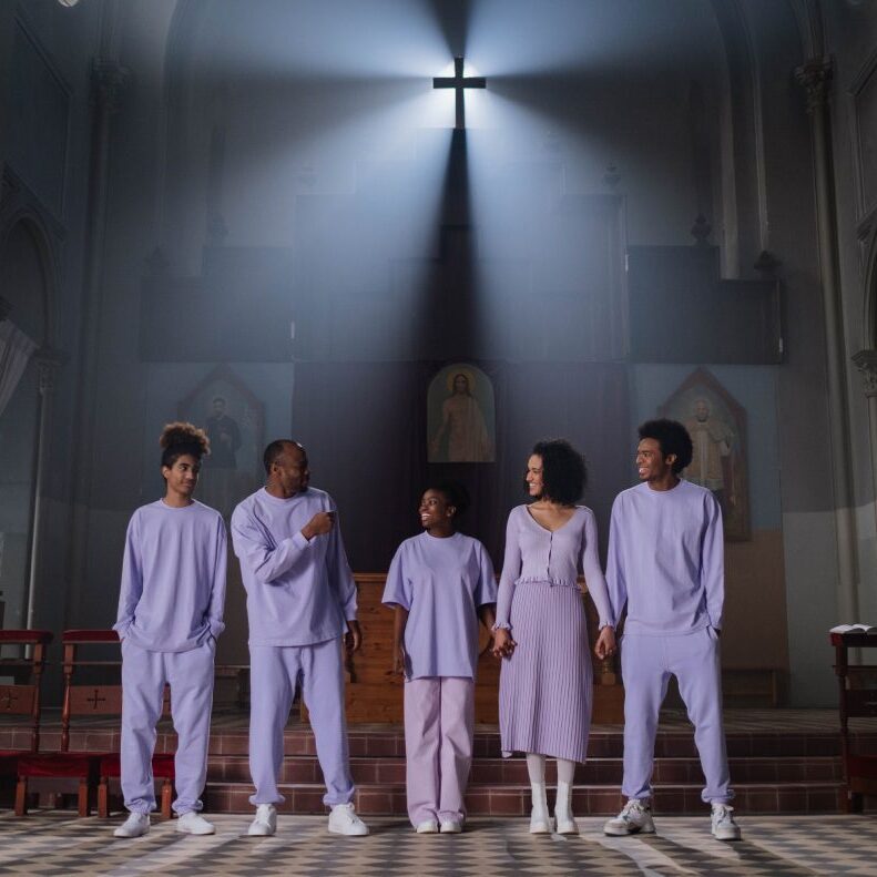 A group of people standing in front of a cross.